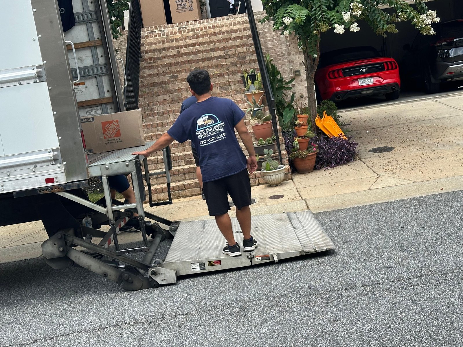 Real Boxed and Loaded mover at the liftgate of the moving truck