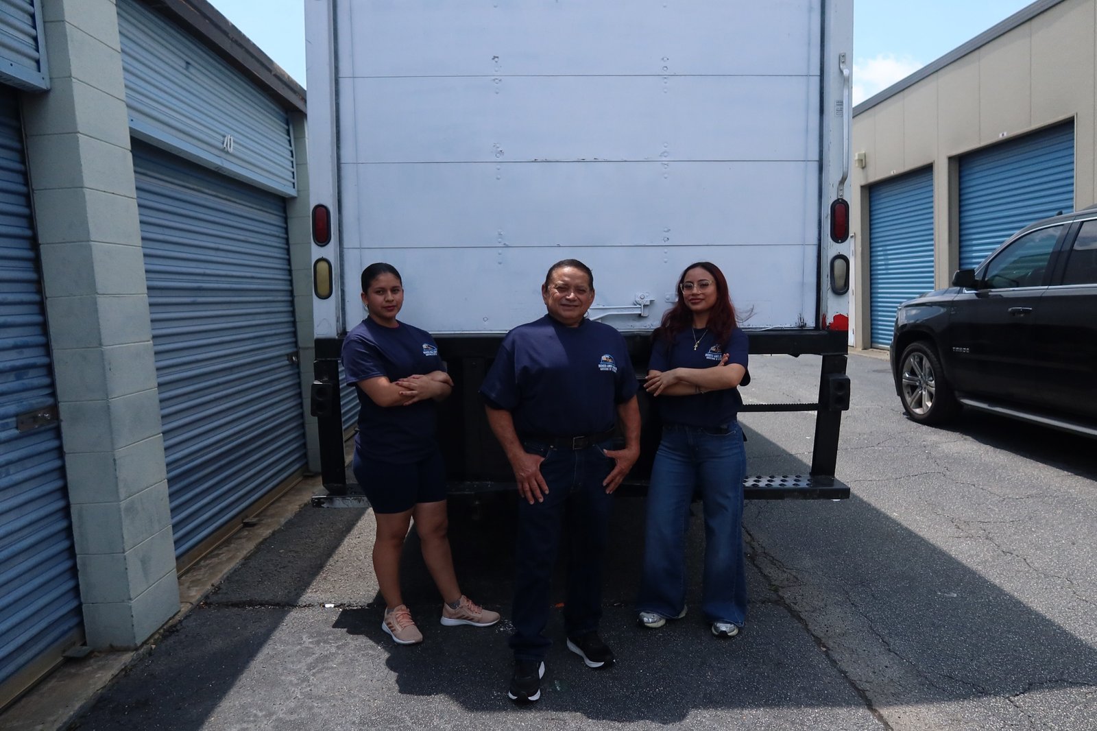 Real Boxed and Loaded Moving & Storage team standing together in uniform beside their moving truck